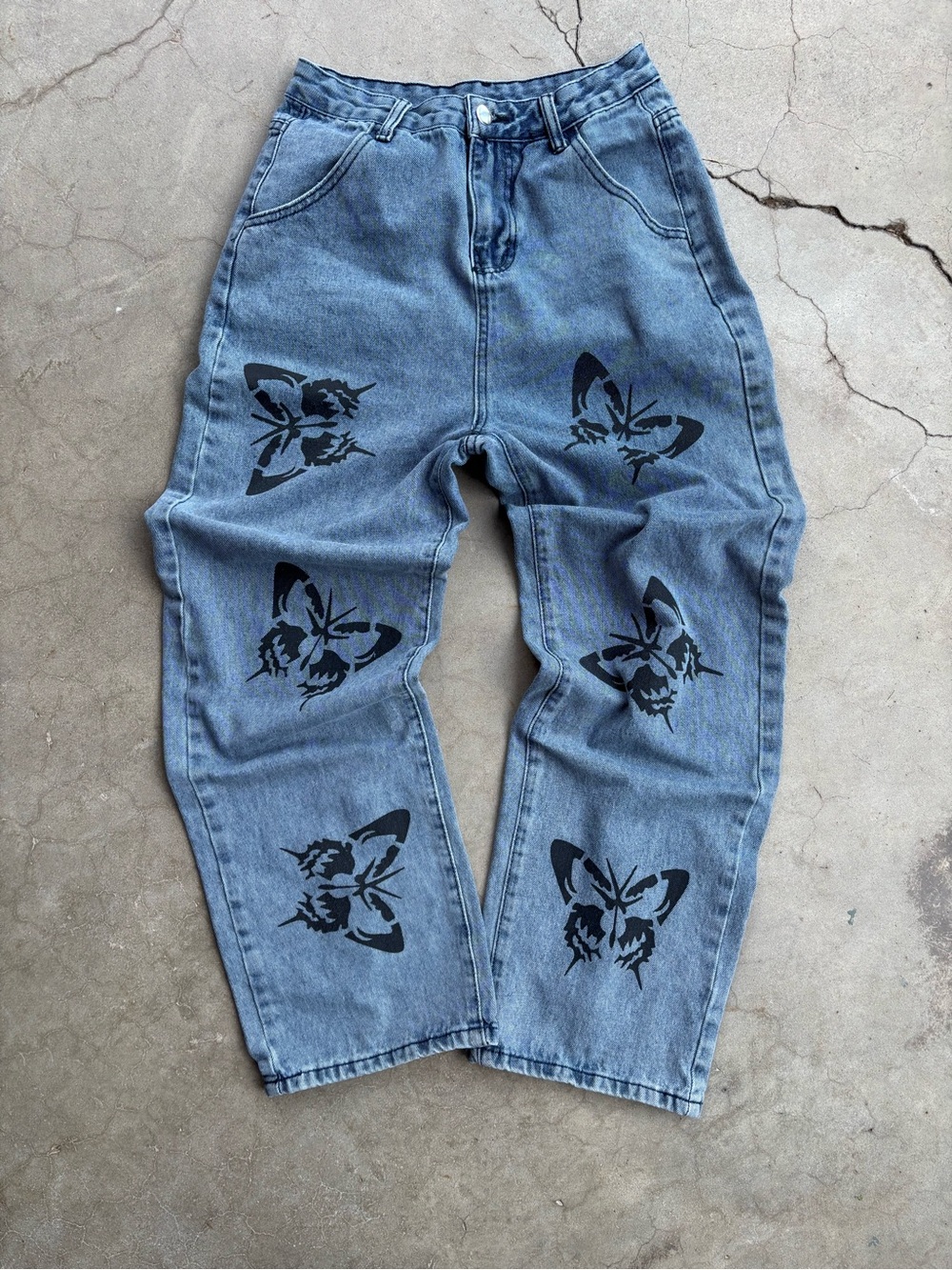 Blue denim high rise jeans with black butterfly design. Approx. women’s size 4.